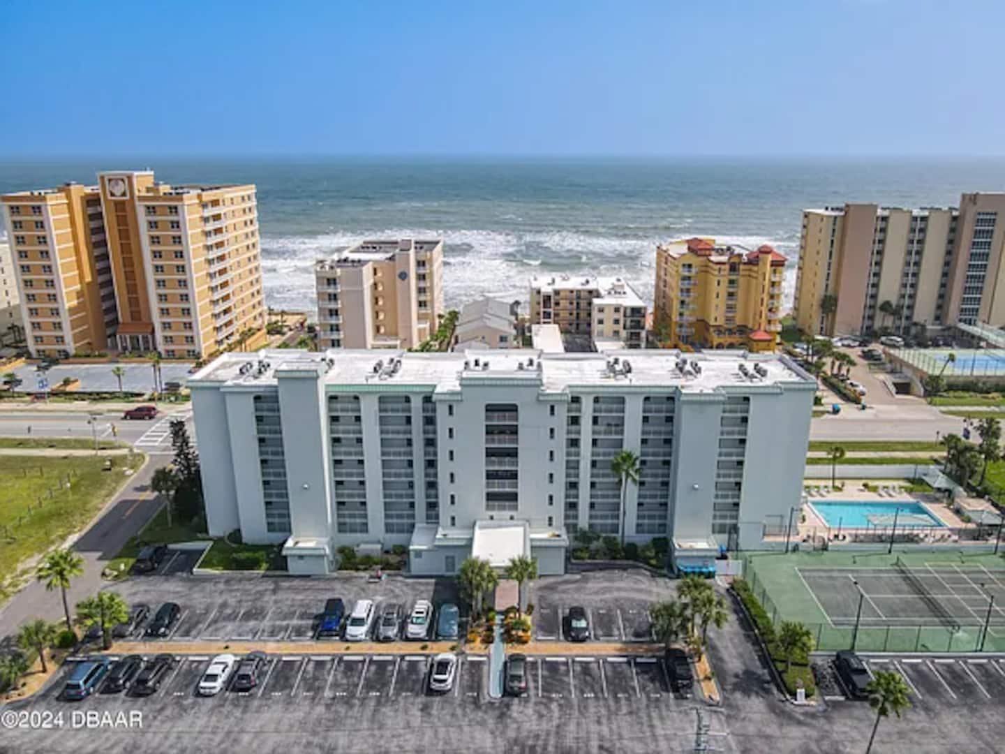 Aerial view of the condo building, pool and the beach